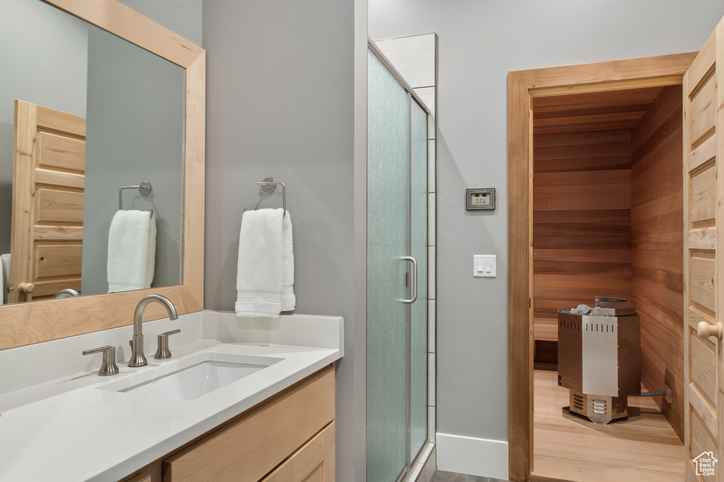 Full bathroom with vanity, a relaxing sauna, a shower stall, and baseboards