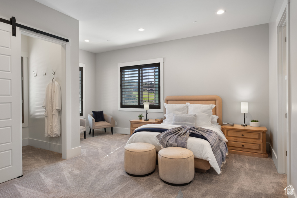 Carpeted bedroom with recessed lighting, a barn door, and baseboards