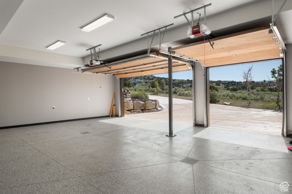 Garage featuring a garage door opener and baseboards