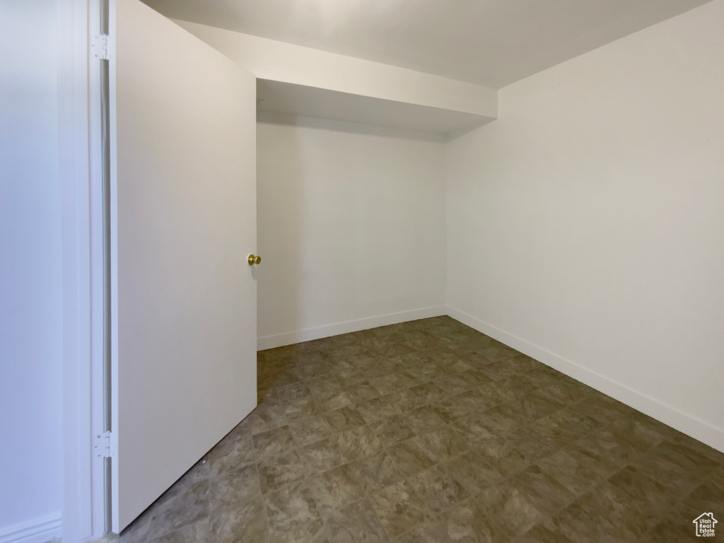 Unfurnished room featuring tile patterned floors and baseboards