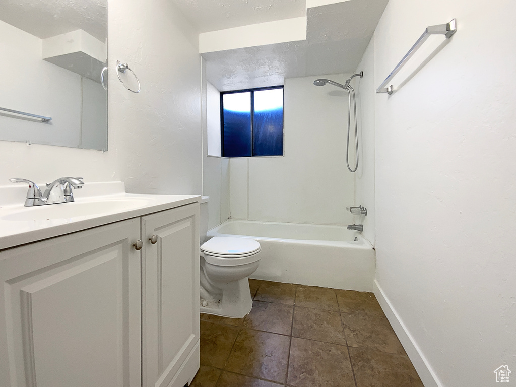 Full bathroom with toilet, vanity, shower / tub combination, baseboards, and tile patterned flooring
