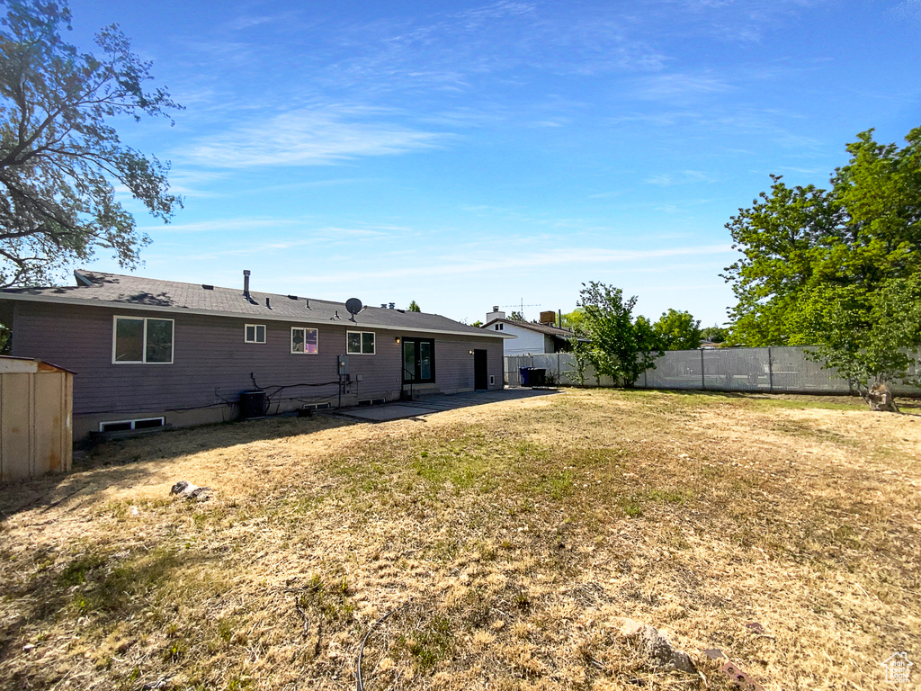 Rear view of property featuring a patio area and a storage shed