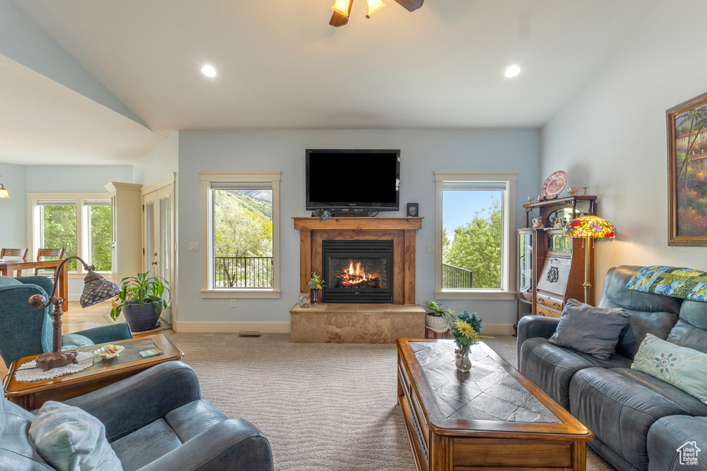 Carpeted living room featuring lofted ceiling, a high end fireplace, ceiling fan, recessed lighting, and baseboards