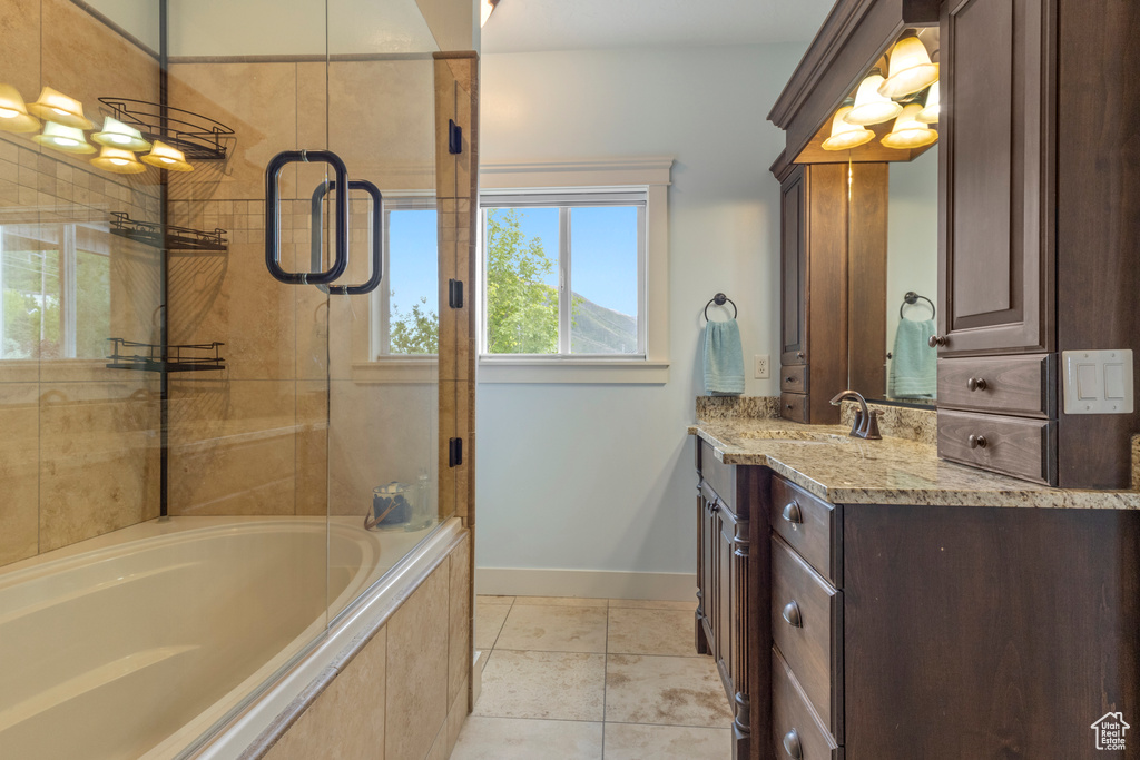 Bathroom featuring baseboards, a tile shower, vanity, a relaxing tiled tub, and tile patterned floors
