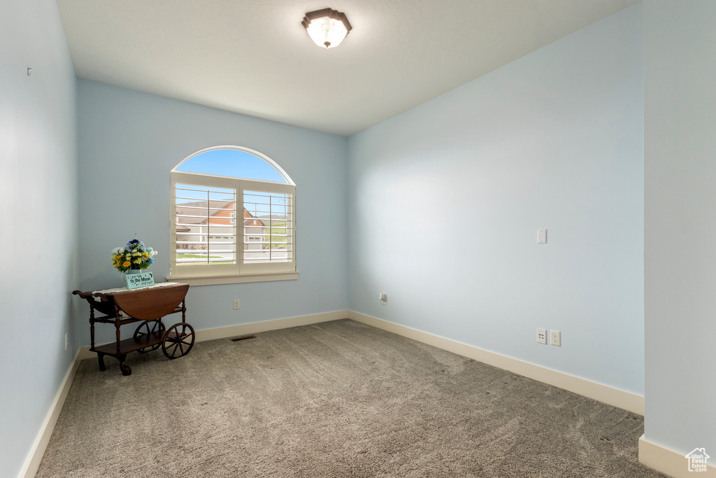 Empty room featuring carpet flooring and baseboards