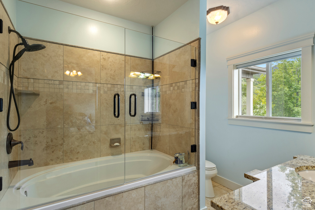 Bathroom featuring tiled shower / bath combo, toilet, tile patterned flooring, and baseboards