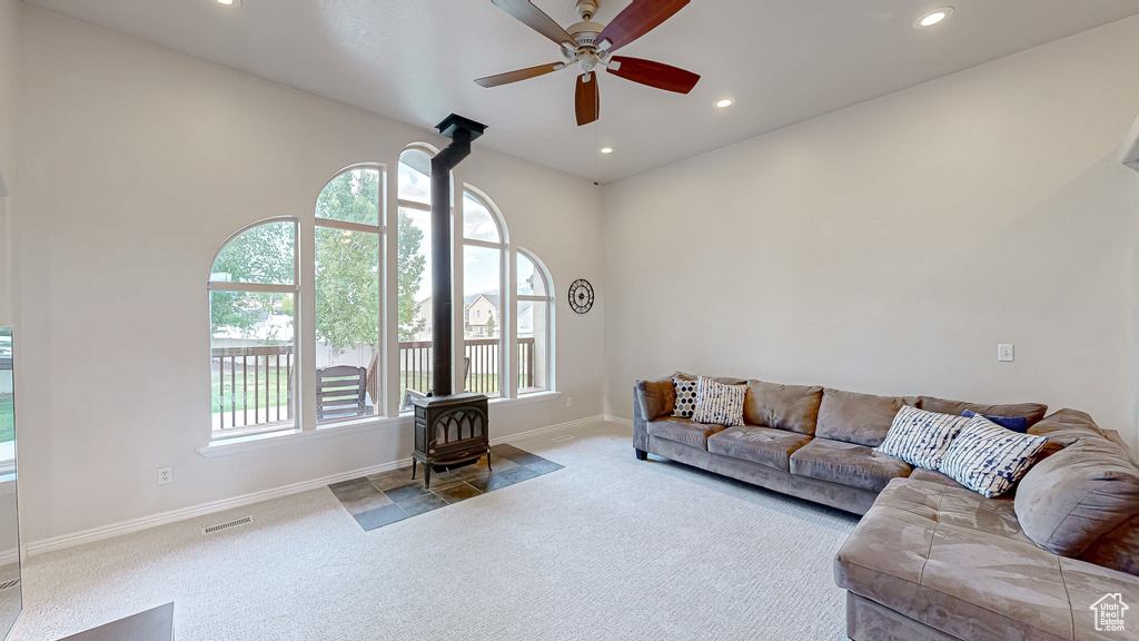 Living area featuring carpet flooring, a wood stove, baseboards, ceiling fan, and recessed lighting