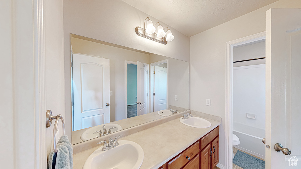 Bathroom with double vanity and toilet