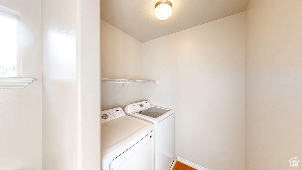 Laundry area with washer and dryer and wood finished floors