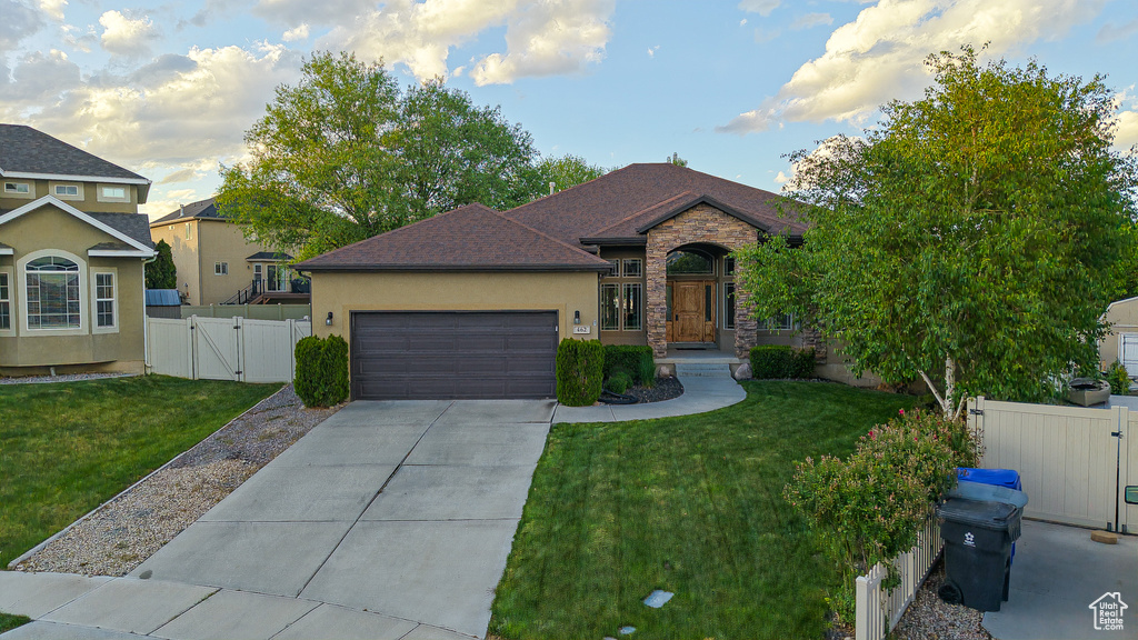 View of front facade featuring a gate, an attached garage, concrete driveway, and stucco siding