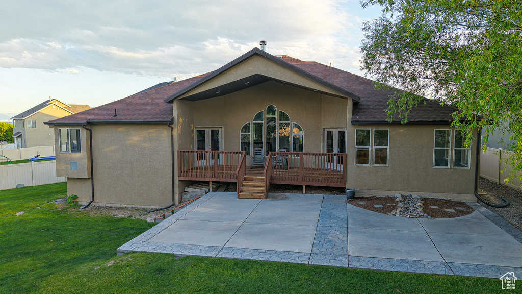 Back of house with a patio, stucco siding, a deck, and a shingled roof