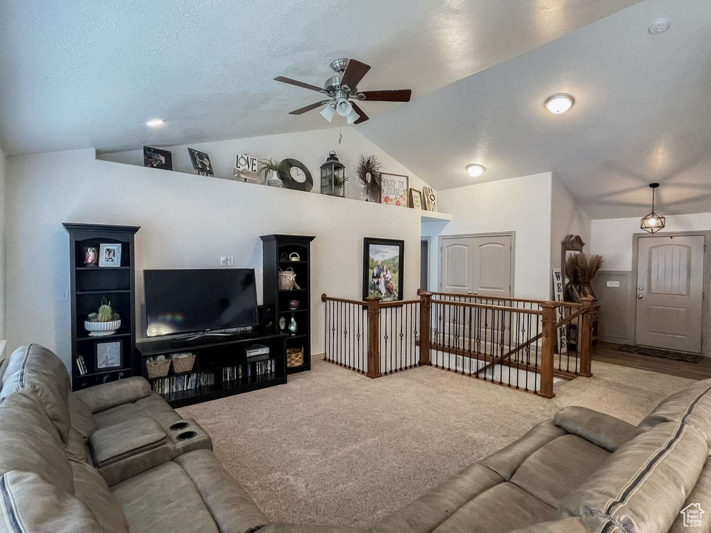 Carpeted living area featuring lofted ceiling and ceiling fan