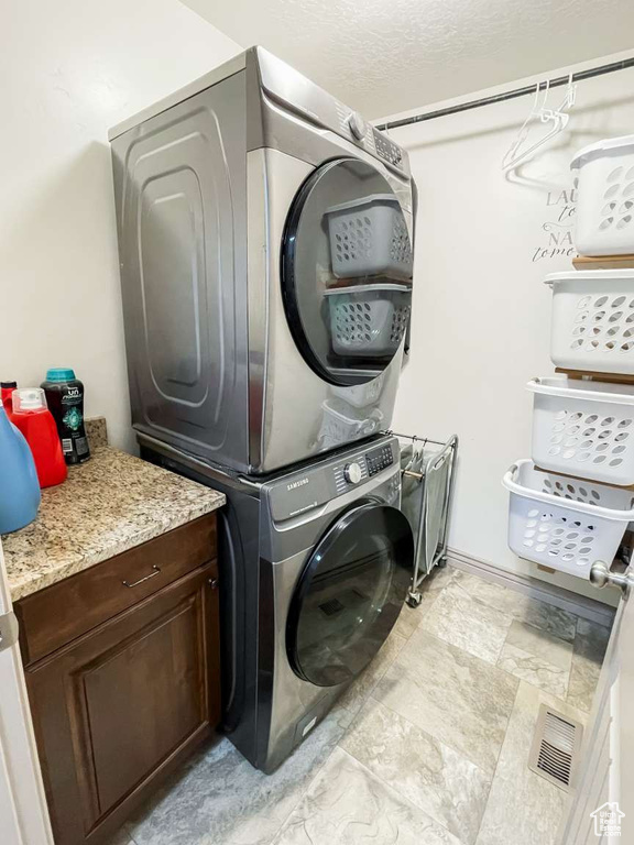 Laundry room featuring stacked washer and clothes dryer