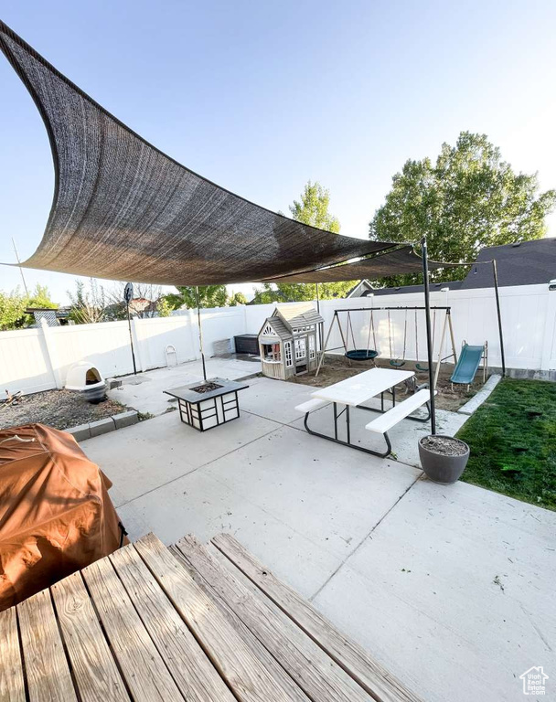 View of community with an outdoor fire pit, a patio, and a fenced backyard