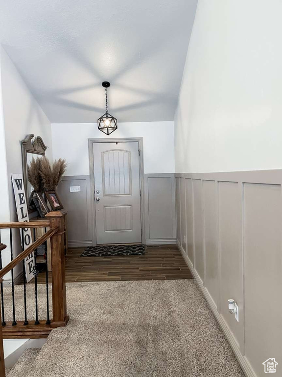 Entrance foyer featuring wainscoting, stairs, wood finished floors, and carpet flooring