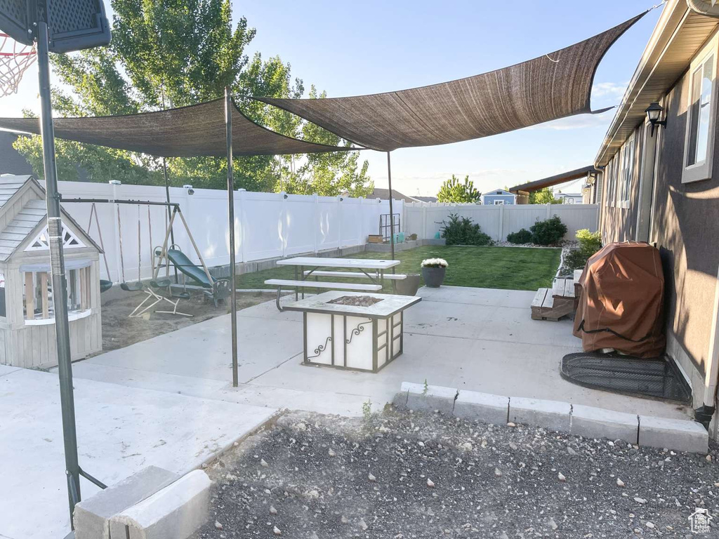 View of patio featuring an outdoor fire pit and area for grilling