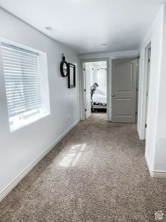 Corridor featuring carpet and baseboards