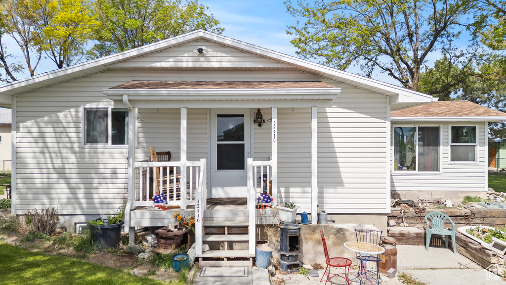 View of front of house featuring roof with shingles and covered porch