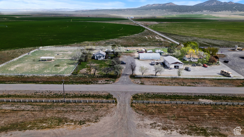 Aerial view of property and surrounding area featuring a mountain backdrop and rural landscape