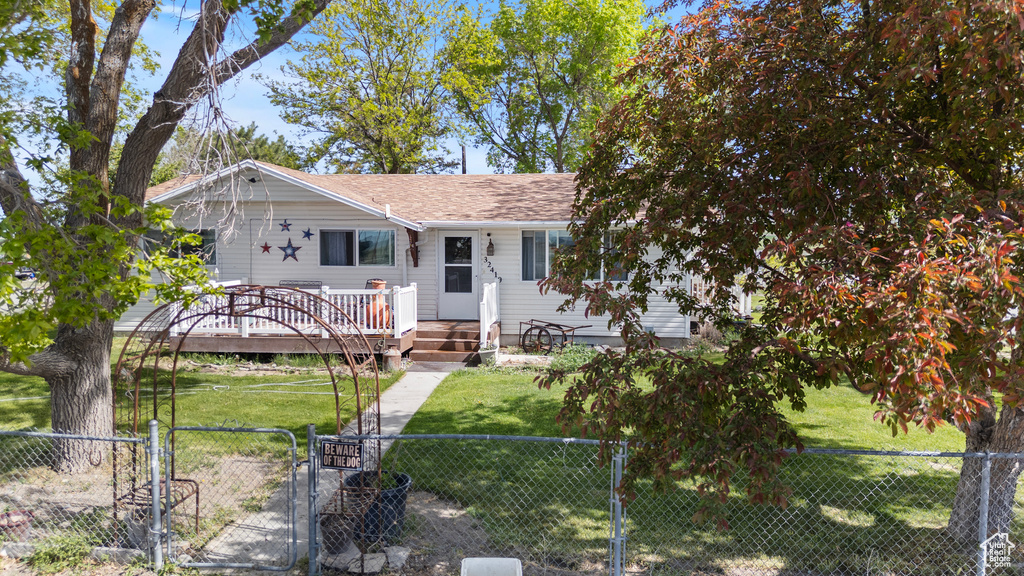 Ranch-style house featuring a gate, a wooden deck, and roof with shingles