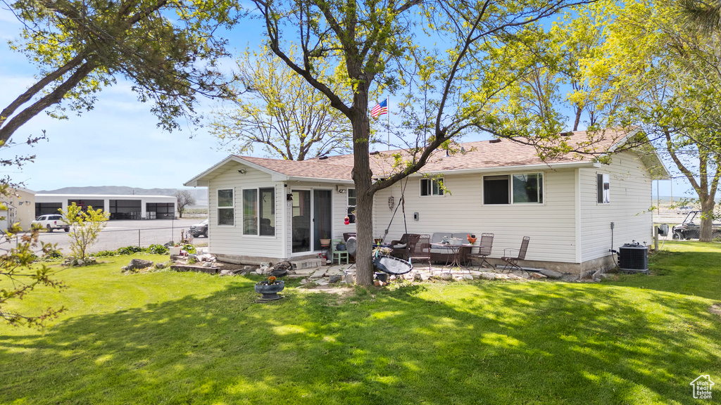 Rear view of house featuring a patio, central AC unit, a sunroom, and outdoor lounge area