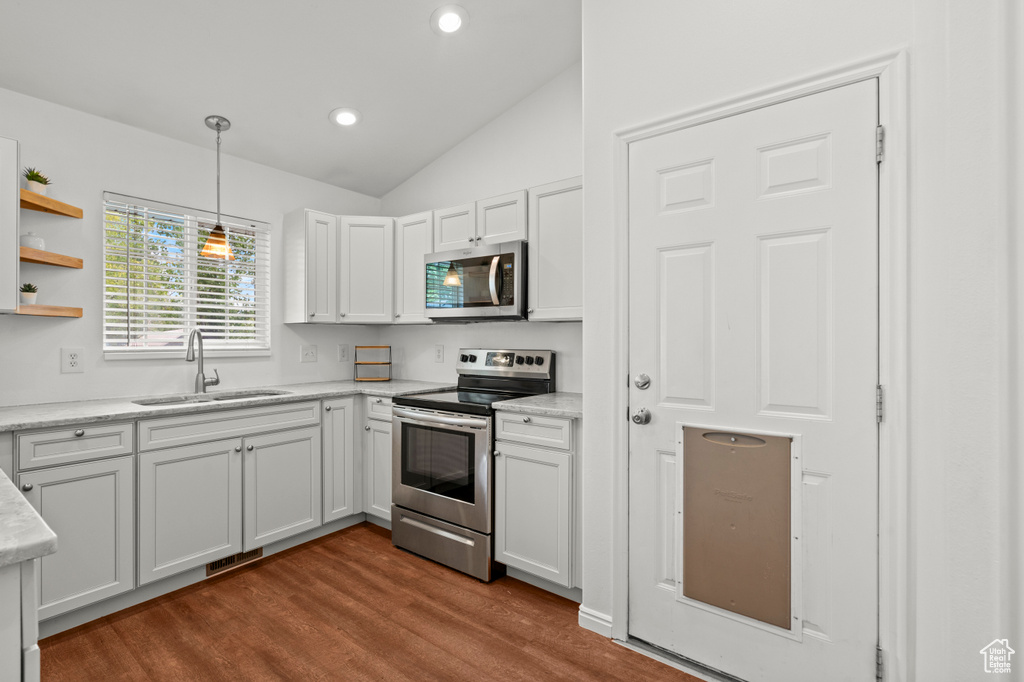 Kitchen with stainless steel appliances, a sink, lofted ceiling, dark wood finished floors, and recessed lighting
