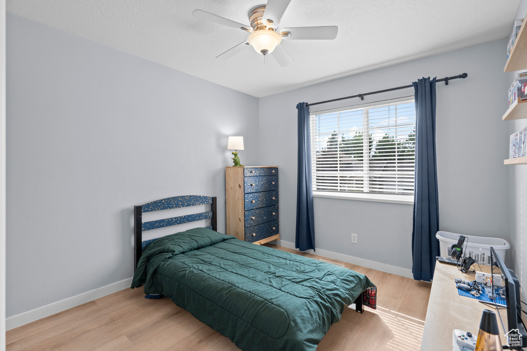Bedroom featuring wood finished floors, baseboards, and ceiling fan
