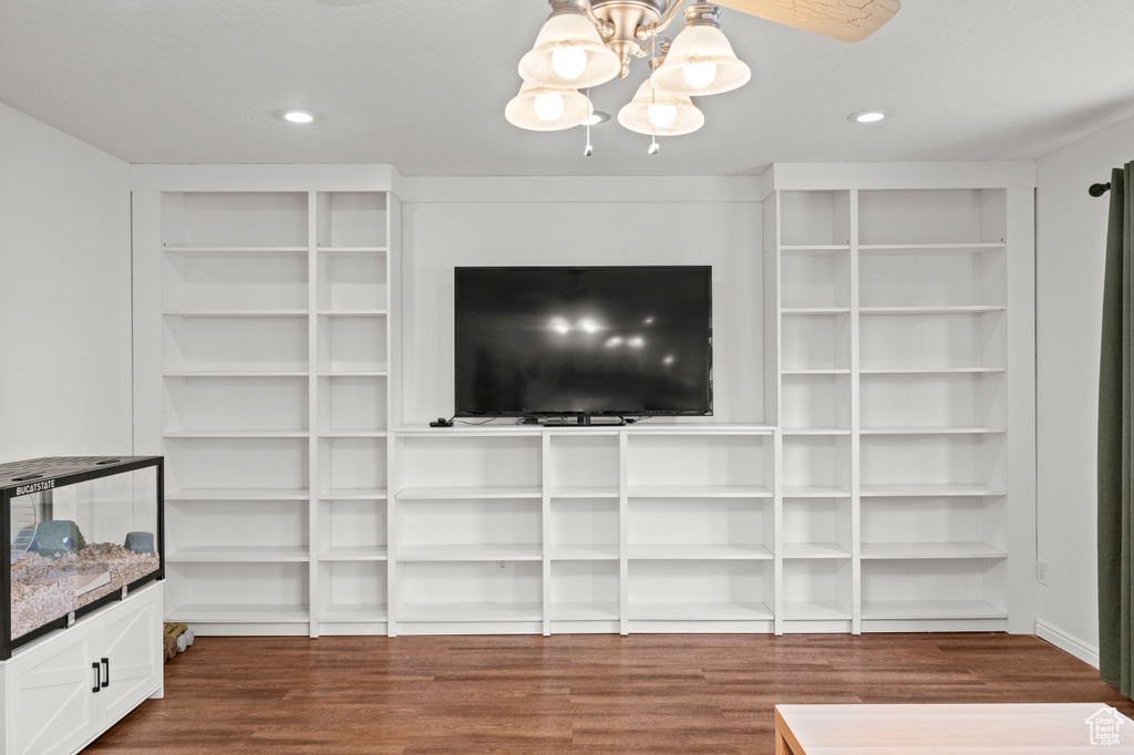 Unfurnished living room featuring dark wood-style flooring, a chandelier, and recessed lighting