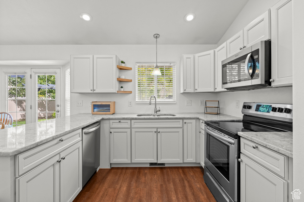Kitchen with stainless steel appliances, a sink, a peninsula, healthy amount of natural light, and recessed lighting