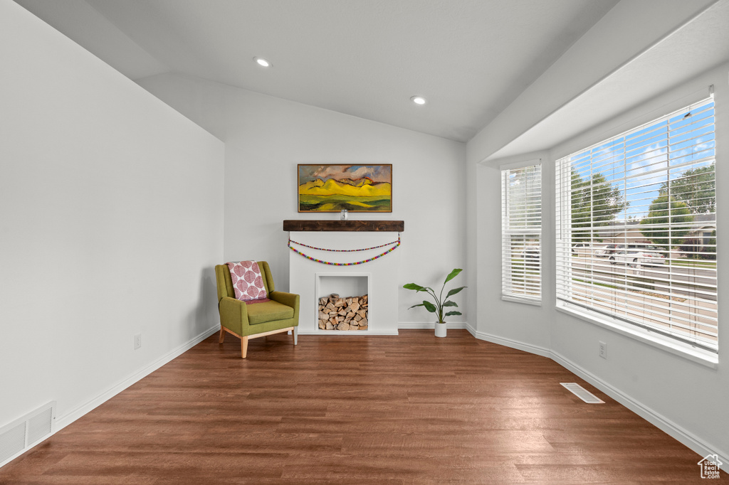 Sitting room with vaulted ceiling, wood finished floors, recessed lighting, and baseboards