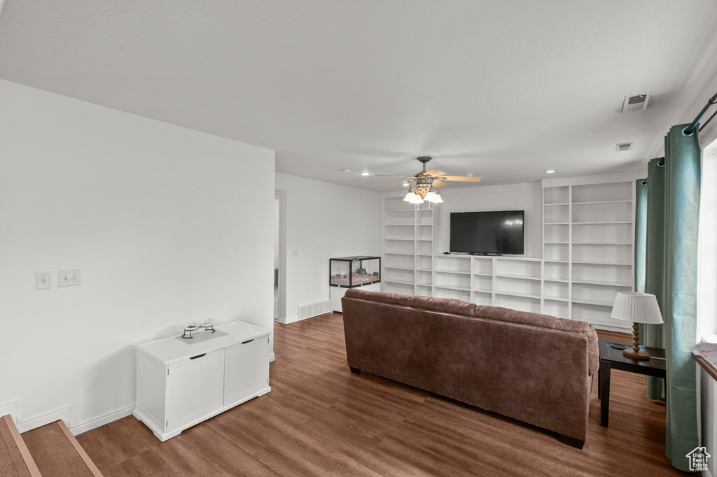 Living room featuring a ceiling fan, wood finished floors, baseboards, recessed lighting, and built in shelves