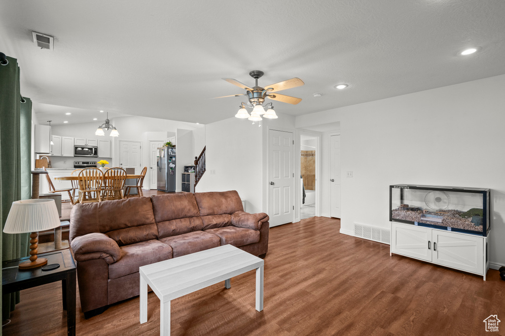 Living room with a ceiling fan, recessed lighting, dark wood-style floors, and baseboards