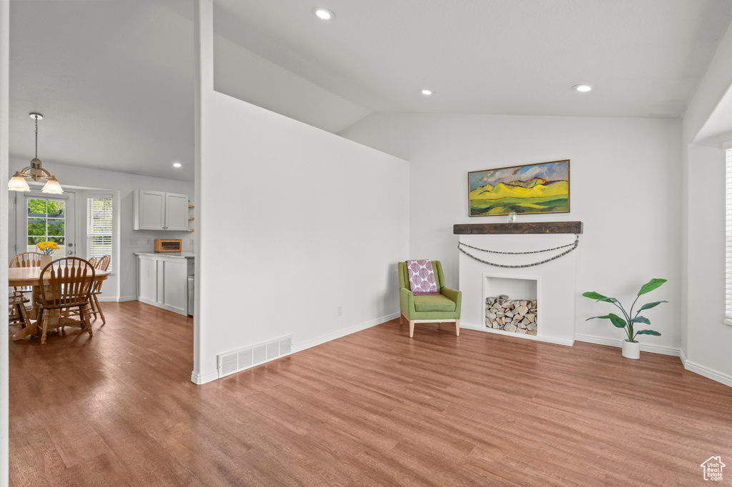 Living area with wood finished floors, recessed lighting, a fireplace, baseboards, and high vaulted ceiling