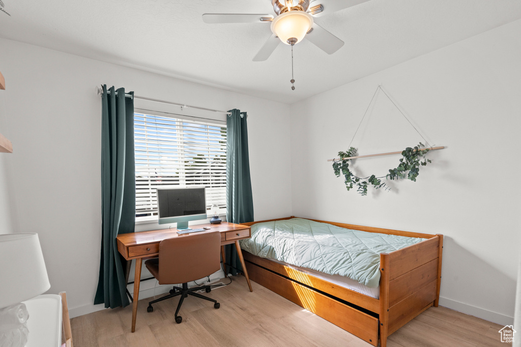 Bedroom with wood finished floors, baseboards, and ceiling fan