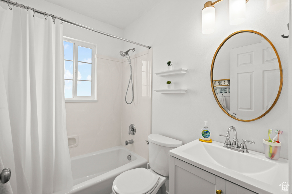 Full bath with shower / bathtub combination with curtain, vanity, and toilet