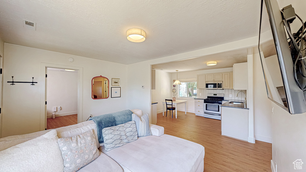 Living area featuring light wood-type flooring and baseboards