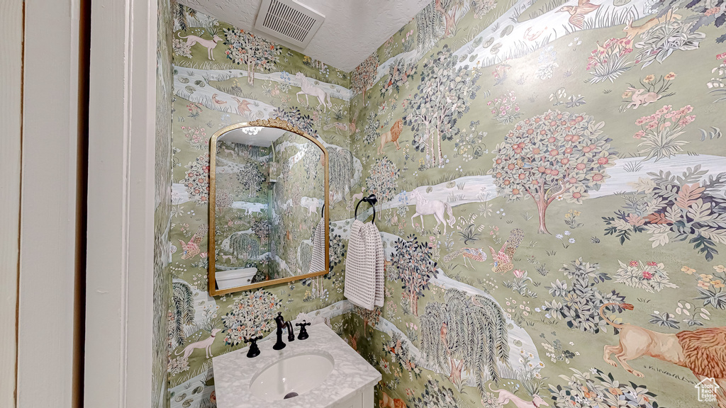 Bathroom featuring vanity and wallpapered walls