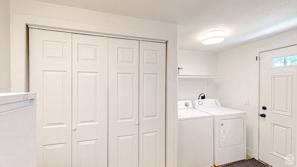 Laundry area featuring washing machine and dryer and a textured ceiling