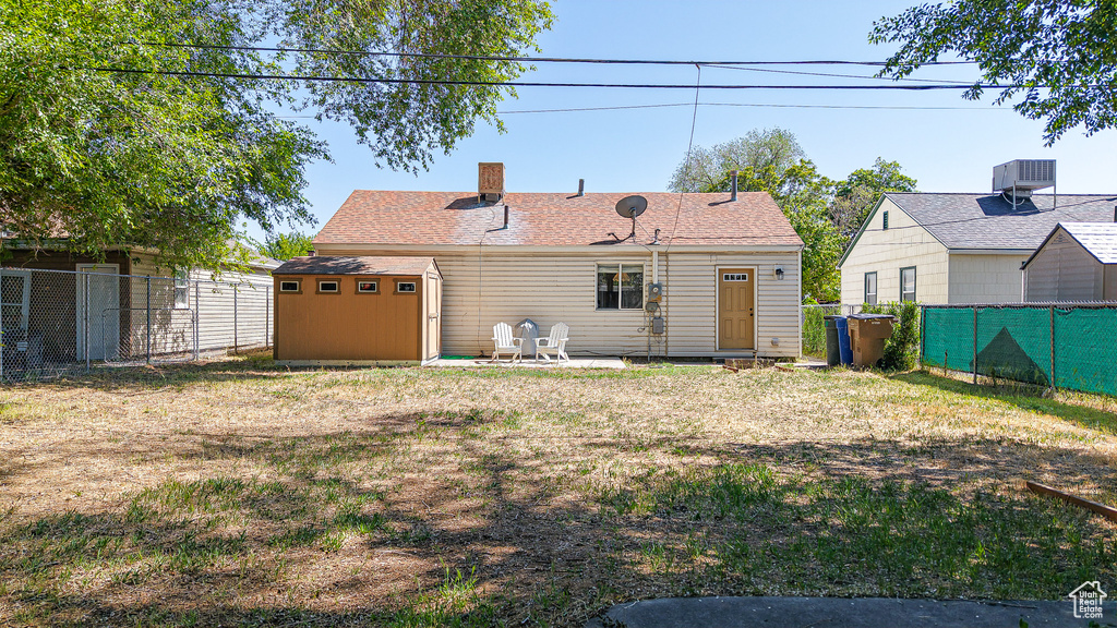Back of property featuring a chimney and central AC unit