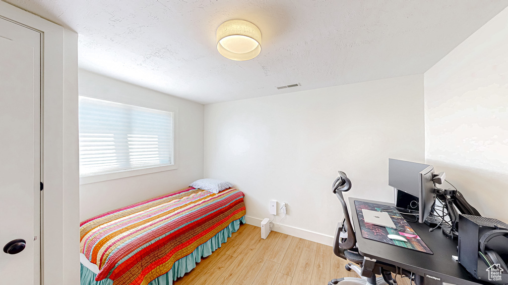 Bedroom featuring wood finished floors and baseboards