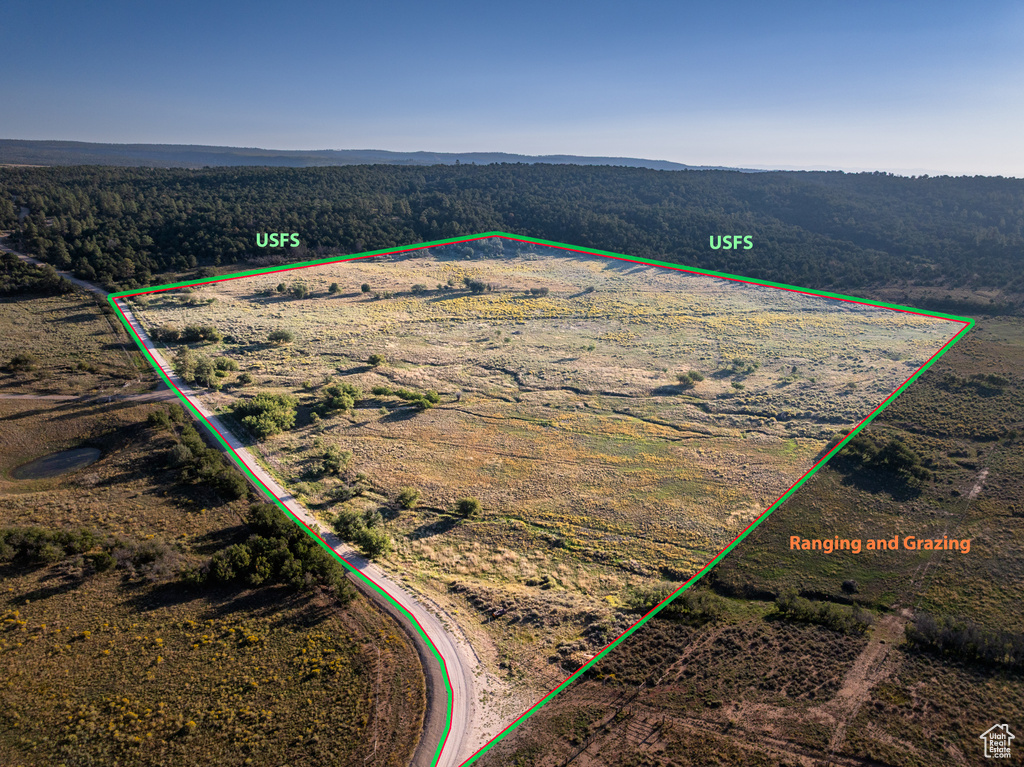 View of rural area featuring property parcel outlined and a heavily wooded area