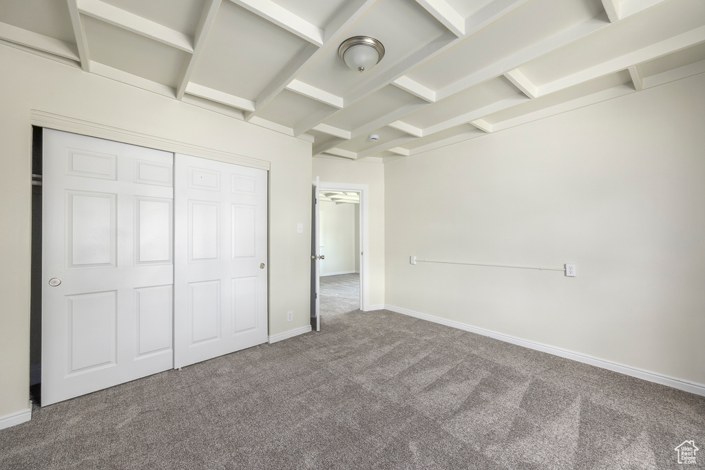 Unfurnished bedroom with carpet, a closet, and baseboards