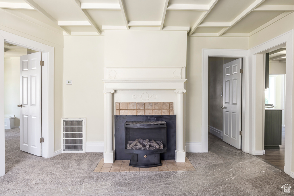 Detailed view of carpet flooring, a tile fireplace, and baseboards