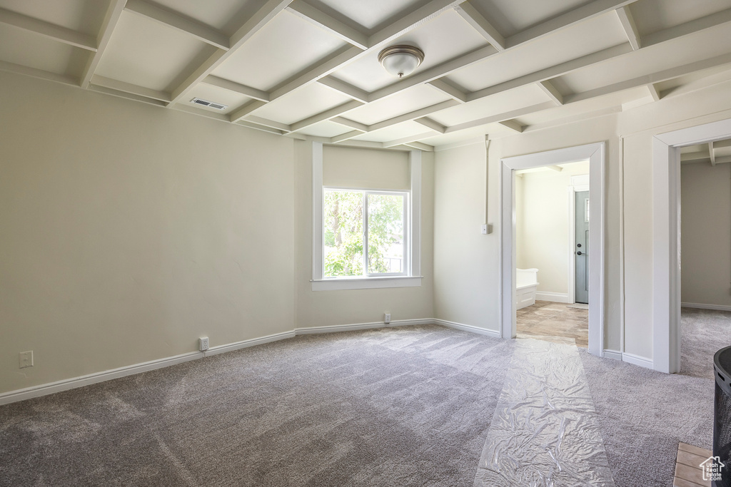 Carpeted empty room with coffered ceiling and baseboards