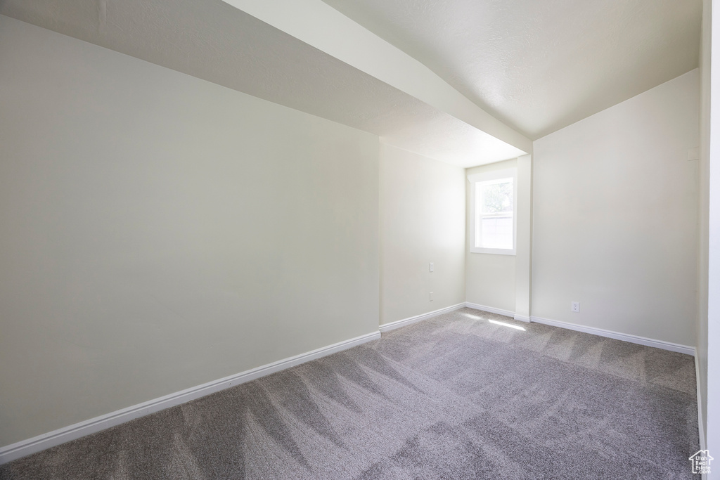 Carpeted spare room featuring baseboards