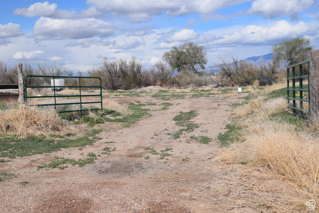 View of road featuring a view of rural / pastoral area, a gated entry, a mountain view, and a gate