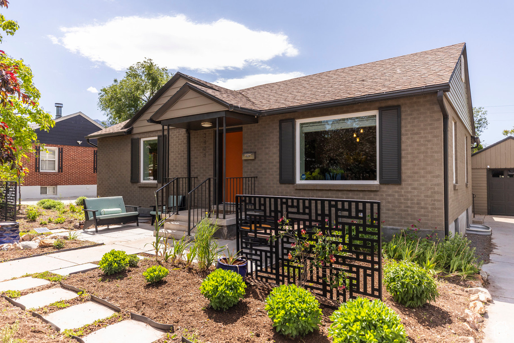 Ranch-style house featuring brick siding, a garage, and an outdoor structure
