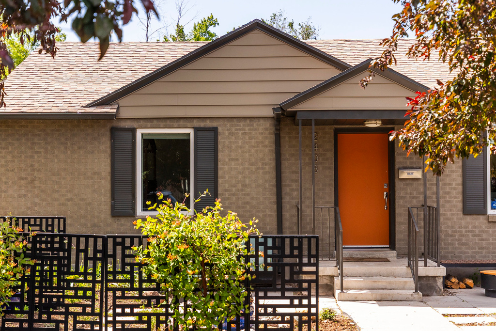 View of front of home featuring a shingled roof and brick siding