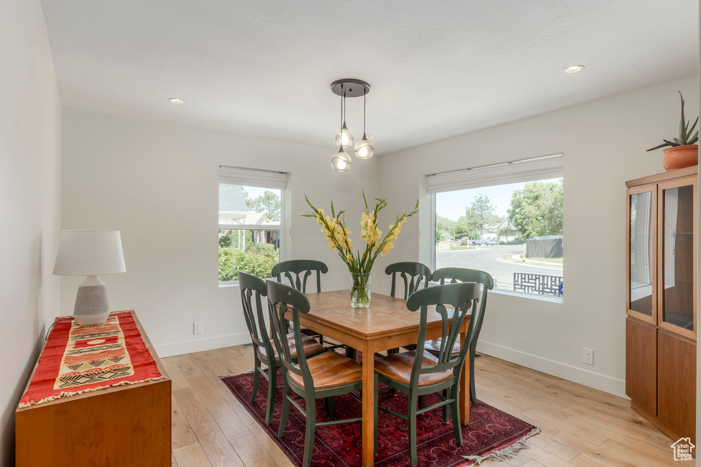 Dining space with healthy amount of natural light, light wood finished floors, baseboards, and recessed lighting