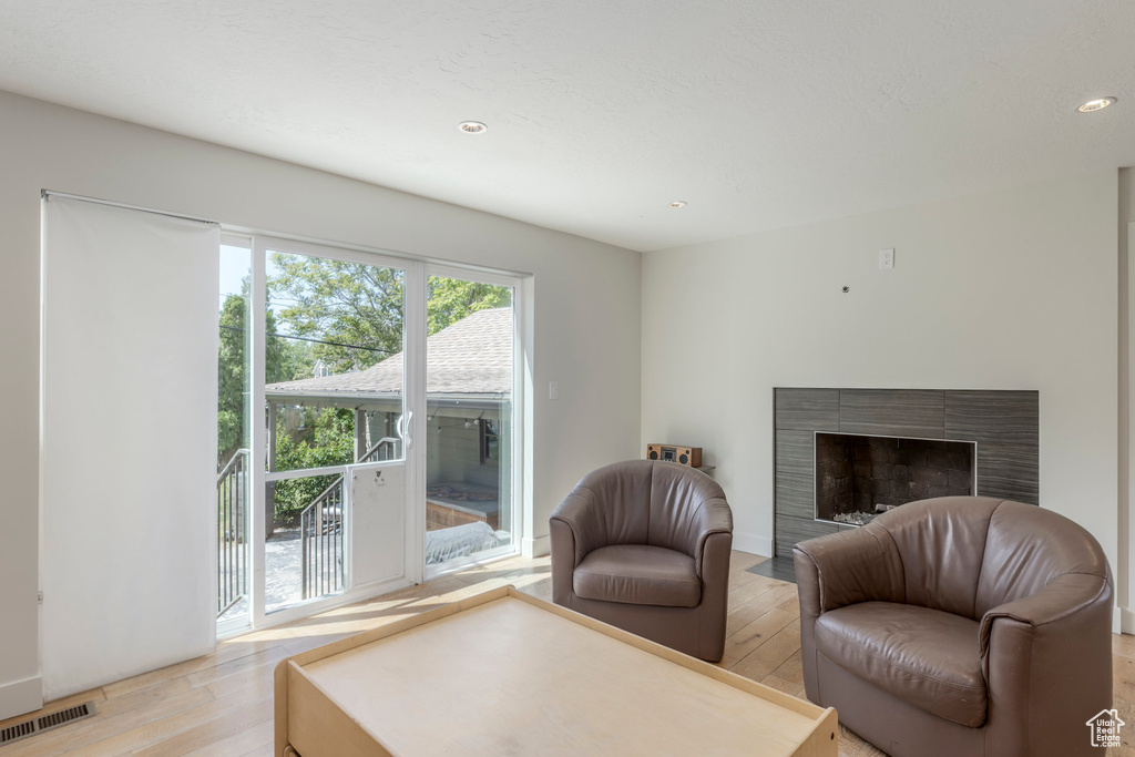 Living room featuring light wood-style floors, recessed lighting, and a tile fireplace